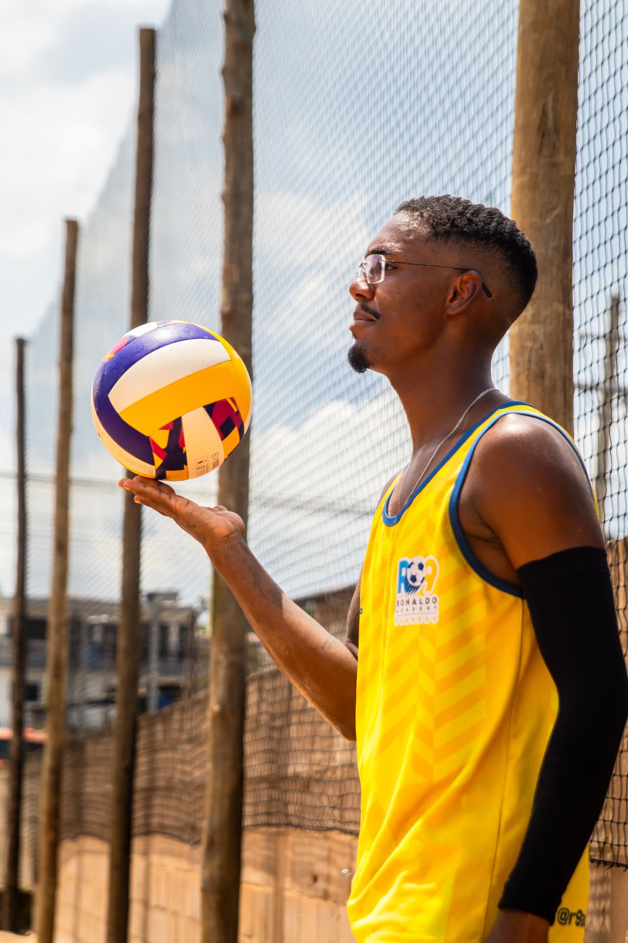 Jogador de footvolley equilibrando a bola na mão em quadra de areia